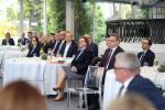 Zastępca Szefa KAS Anna Chałupa podczas uroczystości siedzi przy stoliku wraz z laureatami